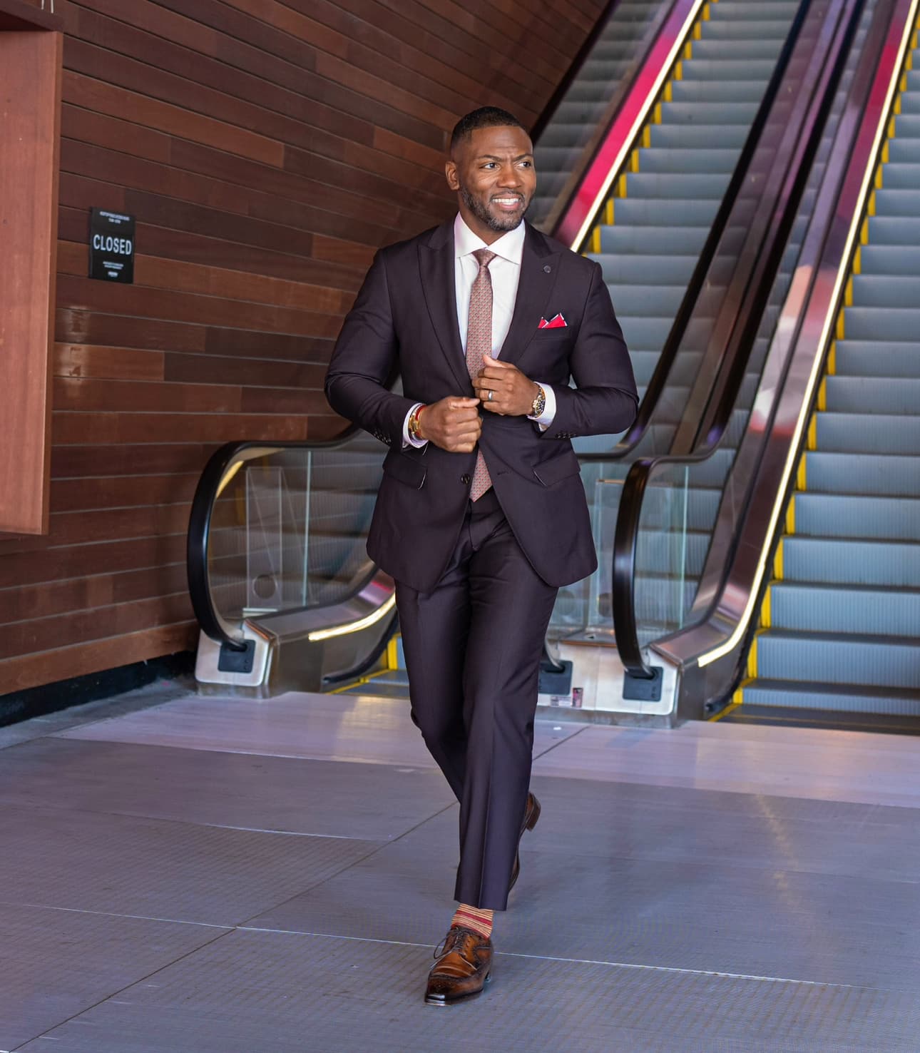Client in a plum tailored suit with brown leather shoes