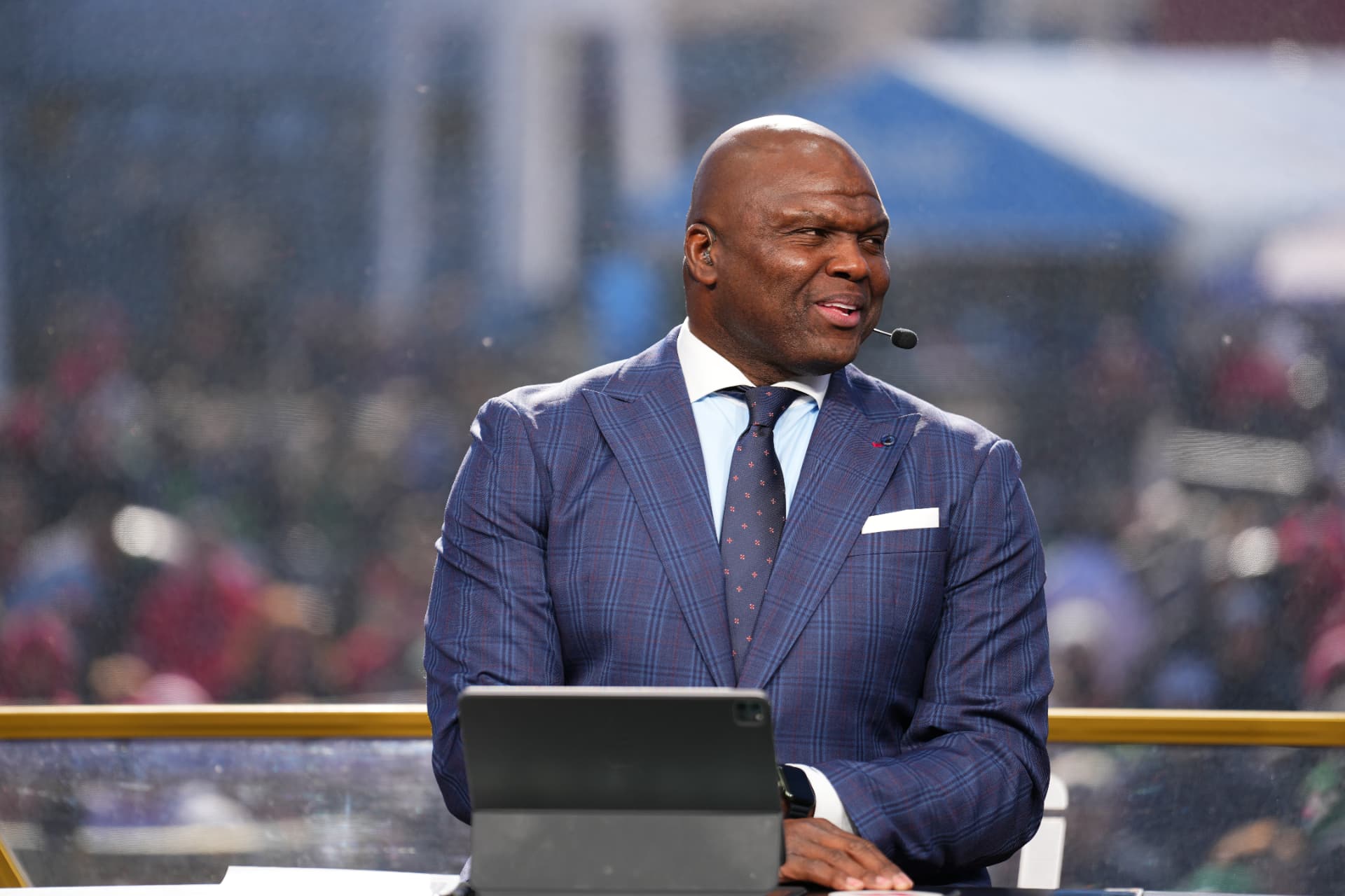 Broadcast analyst in bespoke navy plaid suit at the desk