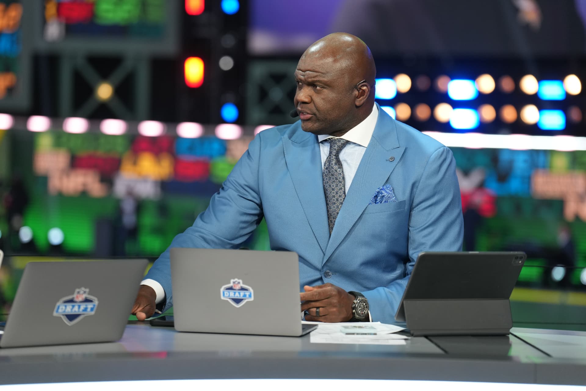 Broadcast analyst in a sky blue suit at the NFL Draft desk